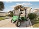 A street-legal golf cart sits on the driveway, with covered seating, custom wheels, and lights at 3319 Thorncrest Dr, The Villages, FL 32162