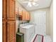 Bright laundry room featuring tile floors, wooden cabinets, and a washer and dryer for convenience at 3319 Thorncrest Dr, The Villages, FL 32162