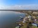 Scenic aerial view shows a waterfront community with lush trees, calm waters and blue skies above at 343 N Mcdonald St # 203, Mount Dora, FL 32757