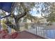 Brick balcony features seating and a view of neighboring houses, surrounded by a large tree with Spanish moss at 343 N Mcdonald St # 203, Mount Dora, FL 32757