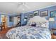 Spacious main bedroom with a king-size bed, sitting area, and blue walls at 343 N Mcdonald St # 203, Mount Dora, FL 32757