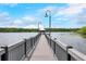 Tranquil view of a wooden pier extending over a serene lake under a bright, cloudy sky at 3480 Soho St # 206, Orlando, FL 32835