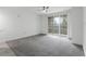 Bright, carpeted living room with neutral walls and a sliding glass door at 3480 Soho St # 206, Orlando, FL 32835