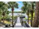 Scenic view from the dock steps through palm trees leading to a beautiful lake at 3480 Soho St # 206, Orlando, FL 32835