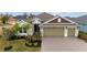 House front with landscaping and three-car garage at 3769 Causey Ct, The Villages, FL 32163