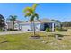 Two-car garage, palm trees, and expansive lawn at 4127 Arlington Ridge Blvd, Leesburg, FL 34748