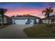 Two-car garage and front yard with palm trees at dusk at 4127 Arlington Ridge Blvd, Leesburg, FL 34748