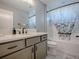 This bathroom features gray vanity, quartz countertop, and a tub with a decorative shower curtain at 4774 Cosentino Ct, The Villages, FL 32163