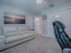 This bedroom features a white sofa, neutral carpet, closet, and a ceiling fan at 4774 Cosentino Ct, The Villages, FL 32163