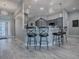 Open-concept kitchen with gray cabinets, modern lighting, and bar seating at 4774 Cosentino Ct, The Villages, FL 32163