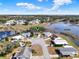 Overhead shot of a lakeside community featuring well-maintained homes under a vibrant sky and greenery at 5338 Tigers Tail, Leesburg, FL 34748