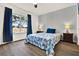 Cozy bedroom featuring an expansive window with view, ceiling fan and wood-look flooring at 5338 Tigers Tail, Leesburg, FL 34748