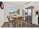 Bright breakfast nook features dark wood floors, natural light from large windows, and modern stainless steel refrigerator at 5338 Tigers Tail, Leesburg, FL 34748