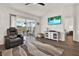 Cozy living room with hardwood floors, comfy seating, and sliding door access to the outdoors at 5338 Tigers Tail, Leesburg, FL 34748