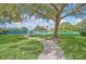 Scenic view of well-maintained tennis courts nestled among lush greenery and mature trees at 5338 Tigers Tail, Leesburg, FL 34748