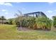 Lush backyard with green lawn and privacy landscaping around the screened pool area at 5424 Donahe Path, The Villages, FL 32163