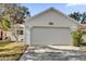 White house exterior with a two-car garage and well-maintained landscaping at 5513 Shriver St, Leesburg, FL 34748