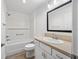 Bright bathroom featuring a shower-over-tub, sleek vanity, and a large, framed mirror at 7260 Draper Ave, The Villages, FL 34762