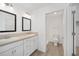 Bathroom featuring double sink vanity, white cabinets, a large mirror and walk in shower at 7260 Draper Ave, The Villages, FL 34762