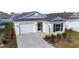 Beautiful exterior of home with two-car garage, pretty landscaping, and screen front door at 7260 Draper Ave, The Villages, FL 34762