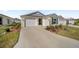 Home with double garage, front yard, and simple landscaping at 7260 Draper Ave, The Villages, FL 34762