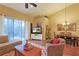 Cozy living room with hardwood floors, a comfortable armchair, and sliding glass doors to the outside at 752 Chacall Loop, Mount Dora, FL 32757