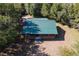 Overhead view of a log cabin featuring a green metal roof, nestled among lush trees at 775 Abeble Rd, Lady Lake, FL 32159