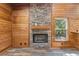 Inviting living room featuring a stone fireplace and warm wood paneling at 775 Abeble Rd, Lady Lake, FL 32159