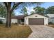 Single story home with brown garage door and paved driveway at 819 Bolivar St, The Villages, FL 32159