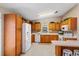 Kitchen with wood cabinets, white appliances, and tile floor at 819 Bolivar St, The Villages, FL 32159