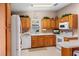 Bright kitchen with oak cabinets, white appliances, and ample counter space at 819 Bolivar St, The Villages, FL 32159