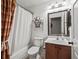 Well-lit bathroom features a shower with a curtain, a single sink vanity, and neutral-colored walls at 8662 Se 133Rd Ln, Summerfield, FL 34491