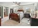 Bright bedroom featuring a ceiling fan, carpet flooring, and windows offering pleasant views at 8662 Se 133Rd Ln, Summerfield, FL 34491