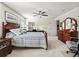 Serene bedroom with carpet floors, ceiling fan, and a wooden dresser and nightstand at 8662 Se 133Rd Ln, Summerfield, FL 34491