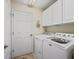 Bright laundry room with white cabinetry and appliances, including a washing machine and dryer at 8662 Se 133Rd Ln, Summerfield, FL 34491