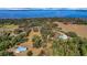 Breathtaking aerial view showcasing a vast estate with waterfront access and mature landscaping at 9210 County Road 48, Yalaha, FL 34797