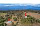 Aerial view showcases the home's location near the lake, and surrounding greenery, highlighting it's peaceful and private setting at 9210 County Road 48, Yalaha, FL 34797