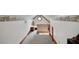 Finished attic with neutral carpet, quaint stained glass window, and eaves storage space, offering unique charm at 9210 County Road 48, Yalaha, FL 34797