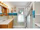 Bathroom with bright sea-themed wallpaper, a vanity with storage, and shower with ocean themed curtain at 9210 County Road 48, Yalaha, FL 34797