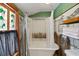 Bathroom featuring a bathtub and shower with stylish decor and a decorative stained-glass window at 9210 County Road 48, Yalaha, FL 34797