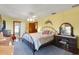 Bedroom with yellow walls, ceiling fan, furniture, and a decorative dolphin wall art at 9210 County Road 48, Yalaha, FL 34797