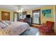 Bright bedroom with hardwood floors features a large bed, dresser, and windows offering views, creating a serene retreat at 9210 County Road 48, Yalaha, FL 34797