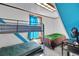 Bedroom with bunk beds, a blue accent wall, and natural light from a window at 9210 County Road 48, Yalaha, FL 34797