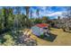 Quaint cottage with a red roof and adjacent vintage windmill situated on a lush, green lawn at 9210 County Road 48, Yalaha, FL 34797