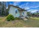 Charming exterior with landscaped front yard, steps leading to the entry and vintage windmill adding curb appeal at 9210 County Road 48, Yalaha, FL 34797