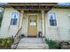 Inviting front porch with decorative columns and a quaint entry door, enhancing the home's welcoming charm at 9210 County Road 48, Yalaha, FL 34797
