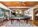 Spacious game room features a pool table, wooden ceiling, and large windows for natural light and relaxing entertainment at 9210 County Road 48, Yalaha, FL 34797