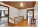Upstairs hallway with hardwood floors leads to various rooms, showcasing the home's architectural details and character at 9210 County Road 48, Yalaha, FL 34797