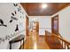 Hallway featuring dark hardwood floors, a stairway, and unique wall decals at 9210 County Road 48, Yalaha, FL 34797