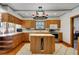 Traditional kitchen with wood cabinets, an island, white countertops, and modern appliances, offers functionality and style at 9210 County Road 48, Yalaha, FL 34797